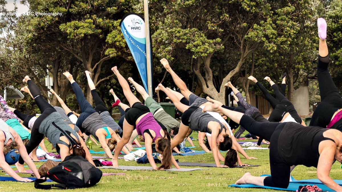 People doing yoga outside on the grass